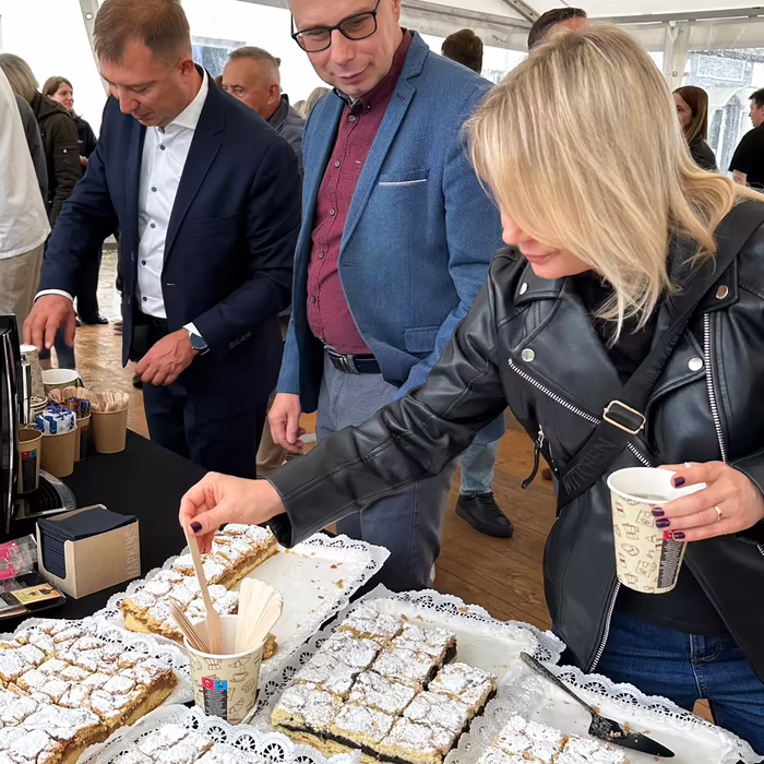 Goście spotkania firmowego przy stole z deserami Manufaktury Rybnickiej